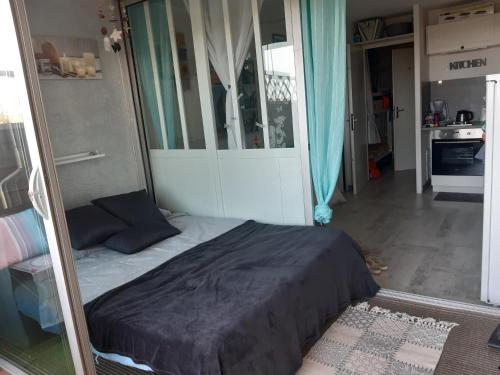 une chambre avec un grand lit dans une pièce dans l'établissement T1 bis cabine vue mer et piscine occitanie, à Fleury