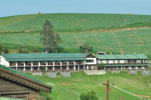 a large building with a green roof in a field at Destiny - The Farm Resort in Ooty