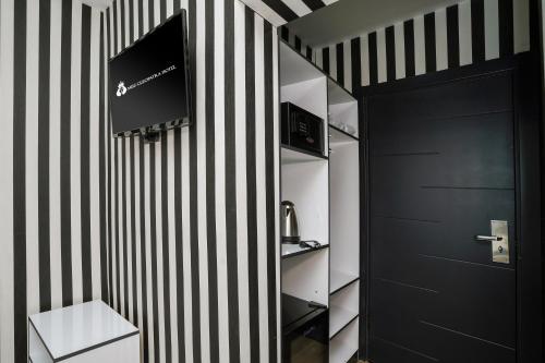 a bathroom with black and white striped walls and a black door at Miss Cleopatra Hotel in Alanya