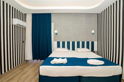 a bedroom with a bed with two towels on it at Miss Cleopatra Hotel in Alanya