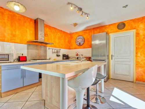 une cuisine avec des murs orange et une grande île dans l'établissement Holiday Home Tina by Interhome, à Naujac-sur-Mer