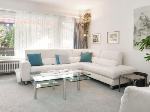 een woonkamer met een witte bank en een glazen tafel bij Apartment Matten - Utoring-19 by Interhome in Zermatt