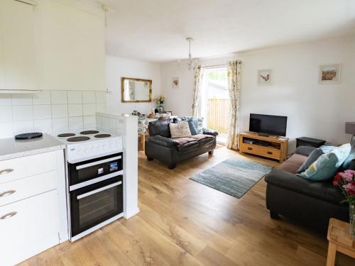 a kitchen and living room with a stove at Holiday Home Oak Cottage by Interhome in Shermanbury