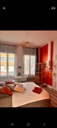 une chambre avec un grand lit aux murs rouges dans l'établissement Appartement vue mer, à Calais