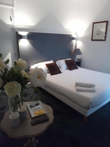 a bedroom with a bed and a table with flowers at Domaine de Bel Air in Cérans-Foulletourte