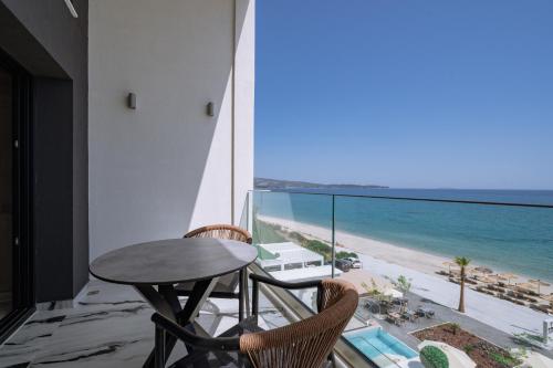a table and chairs in a room with a view of the beach at ZEST THASSOS LUXURY RETREAT in Limenaria