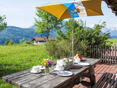 a wooden table with an umbrella on a patio at Holiday Home Marianne by Interhome in Reit im Winkl