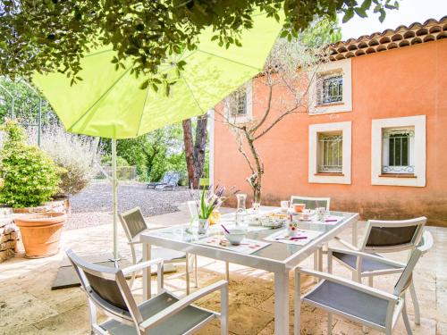 une table avec des chaises et un parasol sur une terrasse dans l'établissement Holiday Home Gombaud by Interhome, à Carcès
