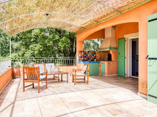 une terrasse avec une table, des chaises et une cuisinière dans l'établissement Holiday Home Gombaud by Interhome, à Carcès