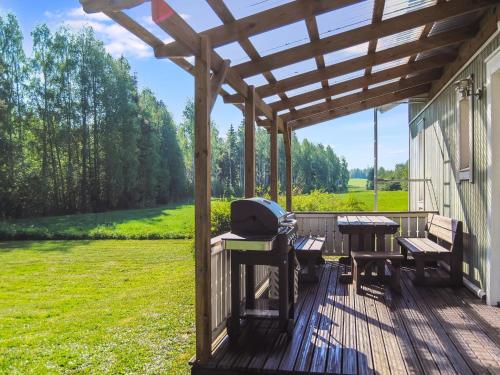 una terrazza in legno con tavoli da picnic e griglia di Holiday Home Kaisla by Interhome a Torvoila