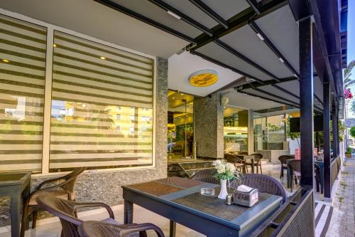 a dining room with a table and chairs on a patio at Miss Cleopatra Hotel in Alanya