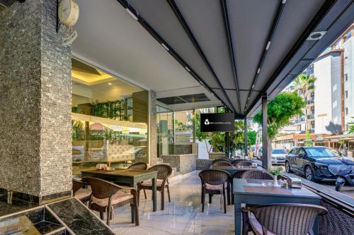 a restaurant with tables and chairs on a patio at Miss Cleopatra Hotel in Alanya