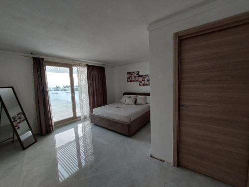a bedroom with a bed and a large window at RIZZO RELAX Residence SALENTO in Capilungo