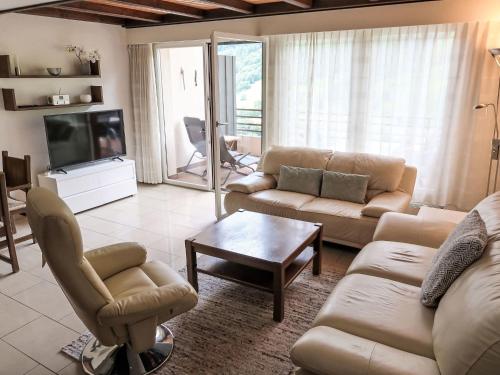 a living room with a couch and a tv at Apartment Ringstrasse - Utoring-50 by Interhome in Leukerbad