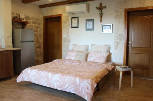 a bedroom with a bed and a refrigerator at Studio apartment Lila in Dicmo