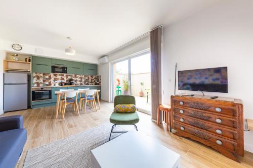 Il comprend un salon avec une grande télévision et une cuisine. dans l'établissement Les Amarres 6 pers Dunes et Mer Blériot plage, à Sangatte