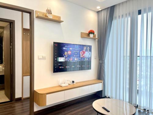 a living room with a flat screen tv on a wall at Căn hộ 2 ngủ nhìn ra núi Thiên Văn in Hai Phong