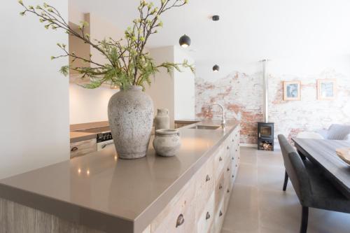 a kitchen with a large vase with flowers on the counter at Zeayou Zeeland - Studio's Zuidstraat 1 in Domburg