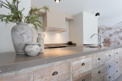 a kitchen with a counter with a vase and a sink at Zeayou Zeeland - Studio's Zuidstraat 1 in Domburg