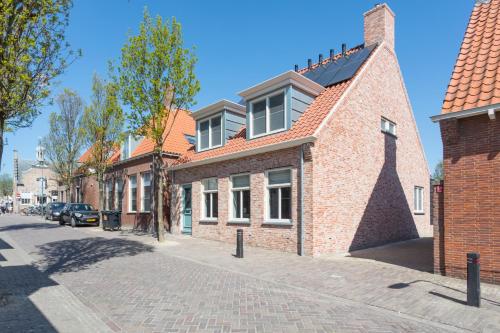 a brick building on a cobblestone street at Zeayou Zeeland - Studio's Zuidstraat 1 in Domburg