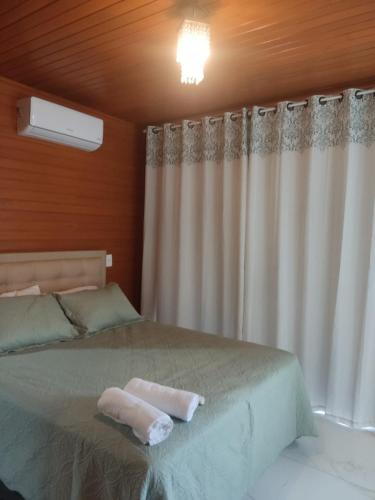 a bedroom with a bed with a white curtain at Urubici Maravilhas da Serra 2 in Urubici