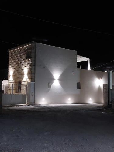 a building with lights on the side of it at night at RIZZO RELAX Residence SALENTO in Capilungo