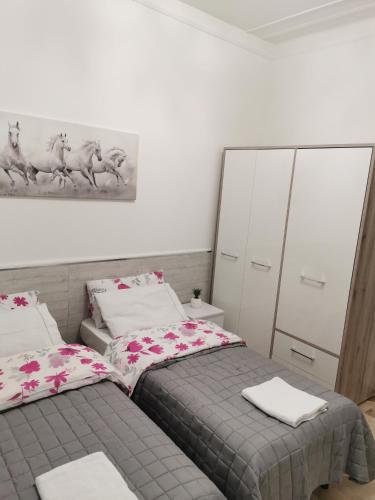 a bedroom with two beds and a painting on the wall at Splendido appartamento in zona centrale in Alessandria