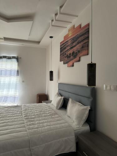 a bedroom with a bed and a painting on the wall at Hotel magicland dakar in Dakar