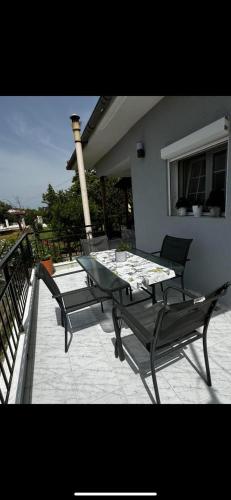 a patio with a table and chairs on a balcony at Elysian Escapes in Epanomi