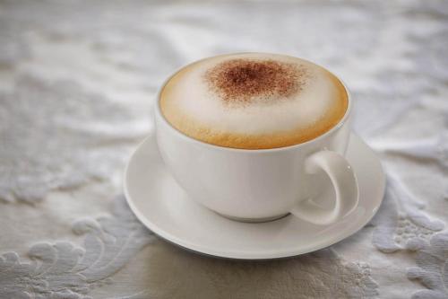 a cup of coffee on a plate on a table at Hotel Giorgio in Athens