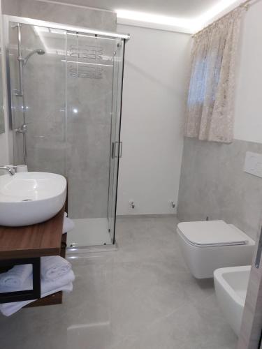 a bathroom with a shower and a sink and a toilet at RIZZO RELAX Residence SALENTO in Capilungo