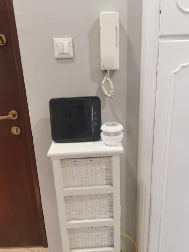 a small white table with a phone on a wall at Splendido appartamento in zona centrale in Alessandria