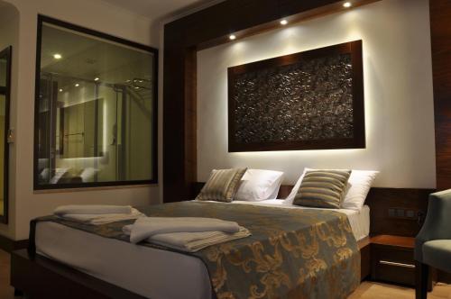 圖爾古特雷伊斯的住宿－圖瑞亞酒店，卧室配有一张床,墙上挂有绘画作品