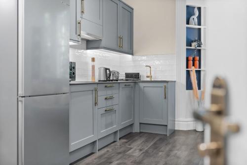 a kitchen with white cabinets and stainless steel appliances at VICHY - The Hampstead Star | Prime Location in London