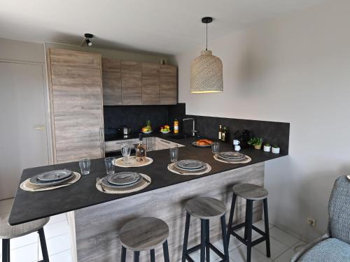 kuchnia z wyspą ze stołem i krzesłami w obiekcie Apartment Le Village - VJ106 by Interhome w miejscowości Saint-Raphaël
