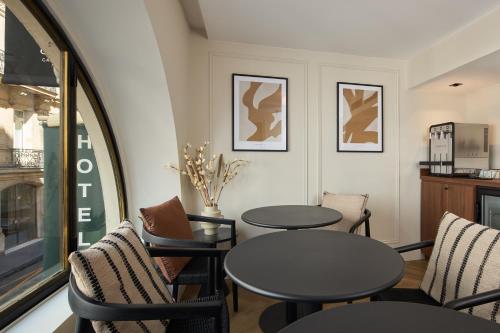 a dining room with two tables and chairs at Hotel Elysée Secret in Paris