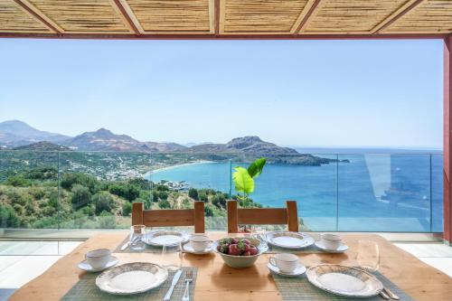 a dining table with a view of the ocean at New Villa Paradosiako with private pool and BBQ near to the Beach in Sellía