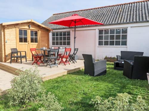un patio avec une table, des chaises et un parasol dans l'établissement Holiday Home Chez Pascaline by Interhome, à Plougasnou