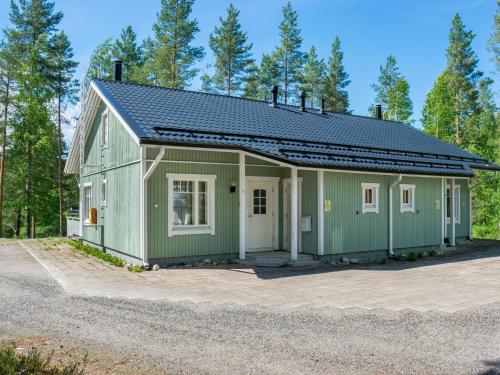 ein grünes Gebäude mit einem Solardach in der Unterkunft Holiday Home Saunaharju 7 by Interhome in Hattusaari