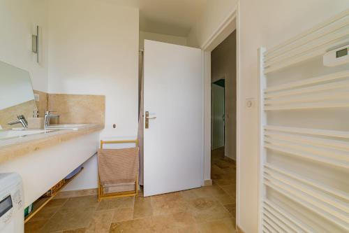 - une cuisine blanche avec un évier et une douche dans l'établissement Haut de villa, vue sur mer à Sainte-Maxime, à Sainte-Maxime