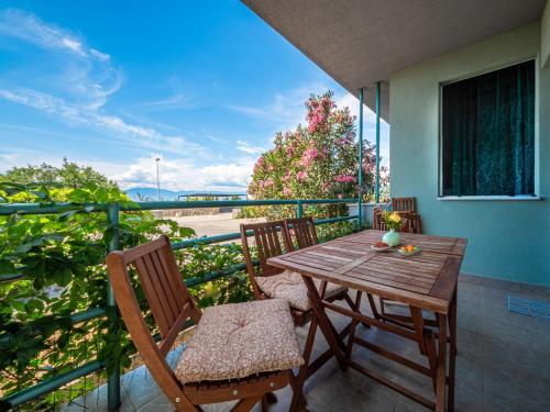 a wooden table and chairs on a balcony at Apartment Alenka by Interhome in Omišalj