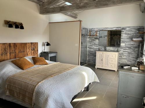 a bedroom with a bed and a brick wall at La petite plaine in Clansayes