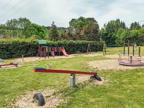 a park with a playground with two swings and a play equipment at Holiday Home JaZ by Interhome in Bedřichov