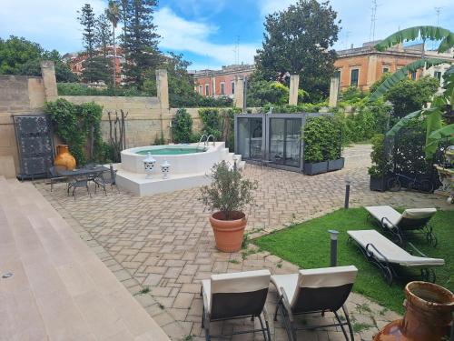 a patio with a hot tub and chairs and a yard at Dimora Charleston Lecce parcheggio privato in loco gratis in Lecce