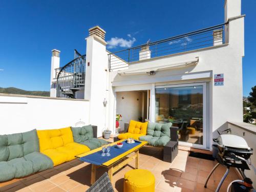eine Terrasse mit gelben und grünen Sofas und einem Tisch in der Unterkunft Holiday Home Sant Genís by Interhome in Llança