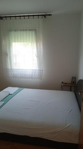 a bedroom with a white bed with a window at Macy 25 in Kotor