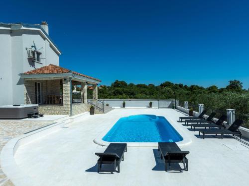 a swimming pool with chairs and a gazebo at Holiday Home Villa Šime by Interhome in Vlašnović