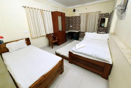 a bedroom with two beds in a room at Jagannath Palace in mayapur
