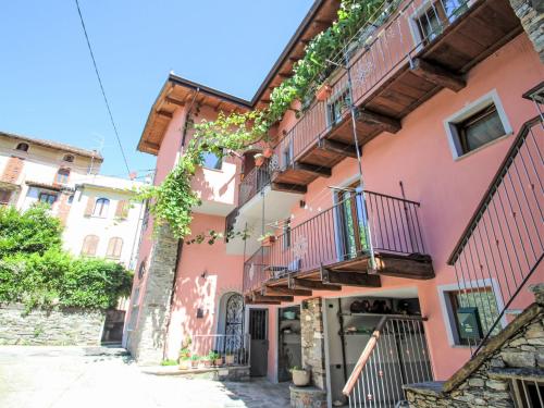 a pink building with stairs and balconies at Apartment Elsa by Interhome in Dumenza