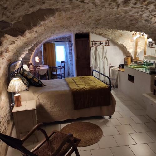 une chambre avec un lit dans une pièce en pierre dans l'établissement Chambres du clocher, à Vallon-Pont-dʼArc